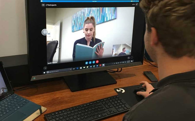 man participating in telehealth video conference with staff member