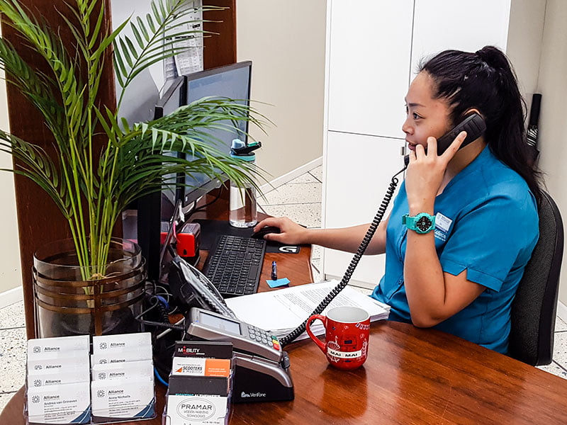 Join our Townsville team Receptionist on phone at Alliance Rehabilitation Townsville