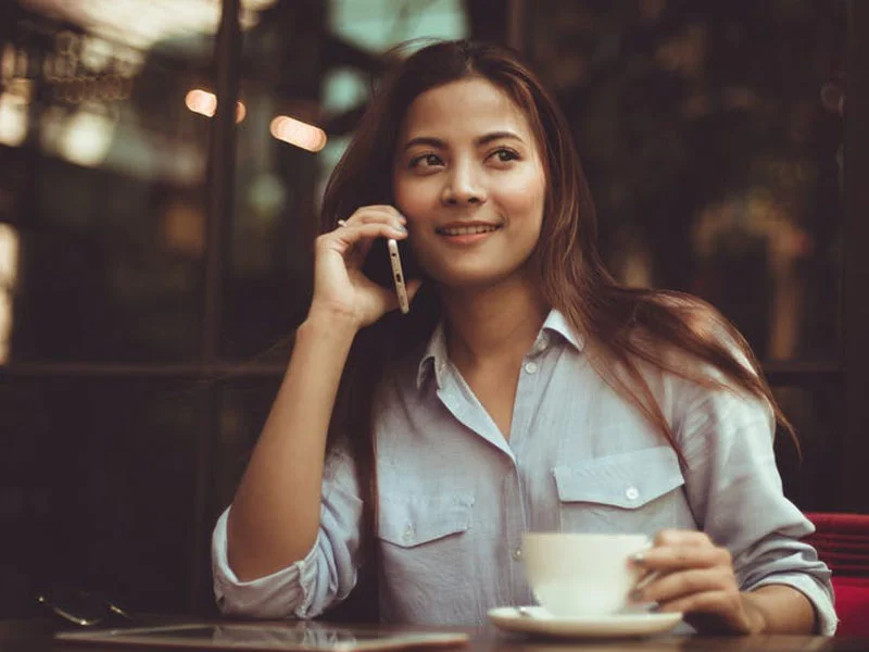 Woman speaking on telephone at a cafe