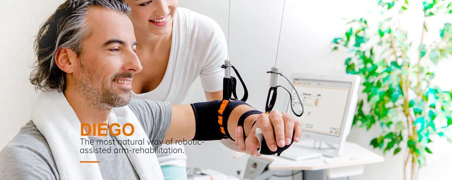 Smiling man using Diego arm assisted rehabiitation